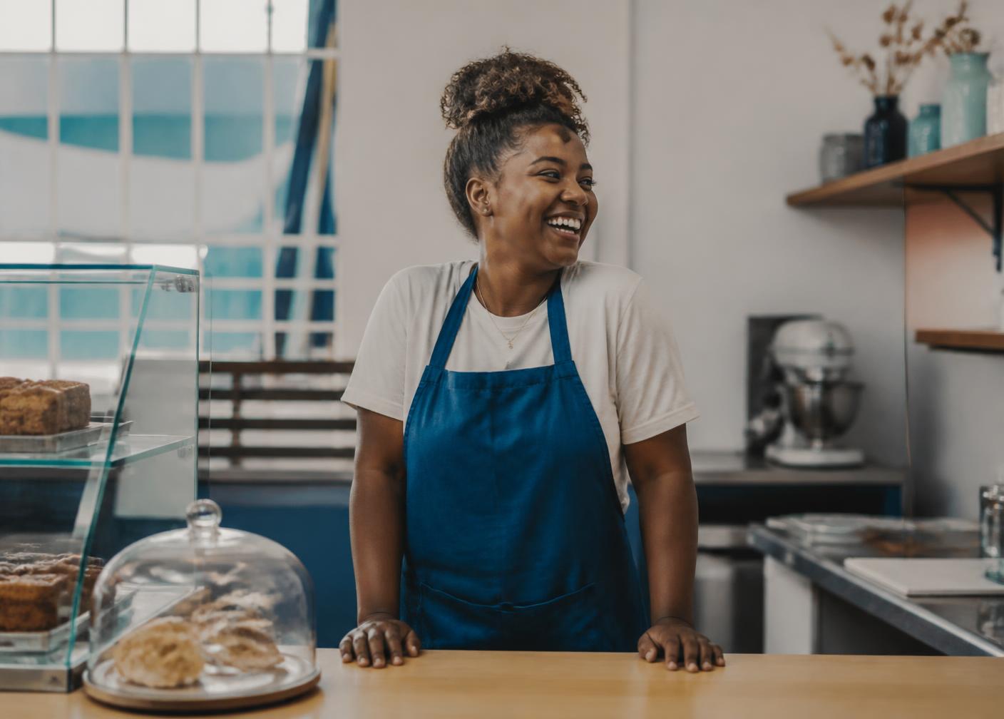 Young Trinidadian bakery owner behind her counter in San Fernando